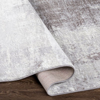 cream abstract rug corner fold on wood floor