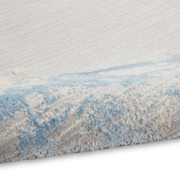 grey sky calvin klein rug partially rolled on white floor