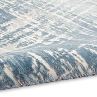 ivory seaglass calvin klein rug partially rolled on white floor