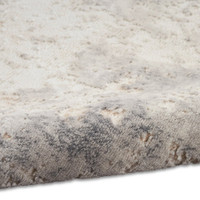 ivory grey calvin klein rug partially rolled on white floor