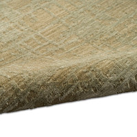green calvin klein rug partially rolled on white floor