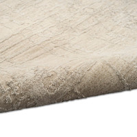 ivory beige calvin klein rug partially rolled on white floor