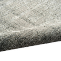 slate calvin klein rug partially rolled on white floor