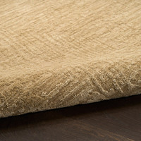 taupe abstract rug partially rolled on wood floor