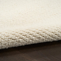 ivory rug partially rolled on wood floor