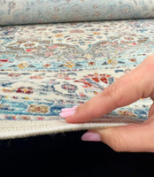 blue gold traditional rug closeup edge on wood floor showing pile thickness