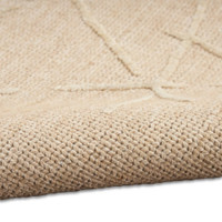natural calvin klein rug partially rolled on white floor