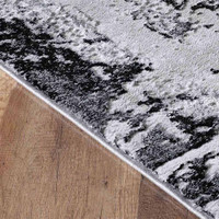 modern abstract acrylic black rug closeup edge on a wooden floor