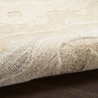 beige abstract rug partially rolled on wood floor