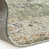 green traditional rug partial fold on white floor