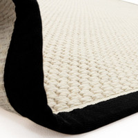 cream wool jute rug partial fold on white floor