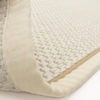 cream wool jute rug partial fold on white floor