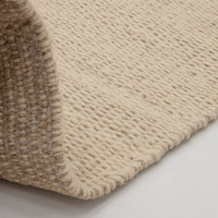 sand flatweave wool rug partial fold on white floor