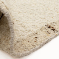 beige wool rug partial fold on white floor