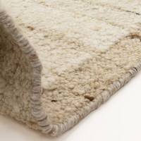 beige wool rug partial fold on white floor