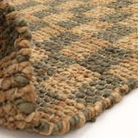 green jute rug partial fold on white floor