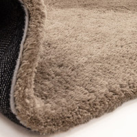 taupe shaggy rug partial fold on white floor