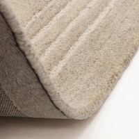 Flipped corner of the Orlo sand wool area rug, showcasing the premium heavy canvas backing and plush pile thickness.