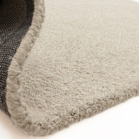 Flipped corner of the Theodore Chevron sand wool rug, displaying its heavy canvas backing and plush, thick texture.