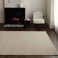 Minimalist living room setting featuring a cream-colored ribbed wool rug on dark wood flooring.