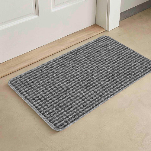 grey non-slip dirt trapper mat in front of a door indoors