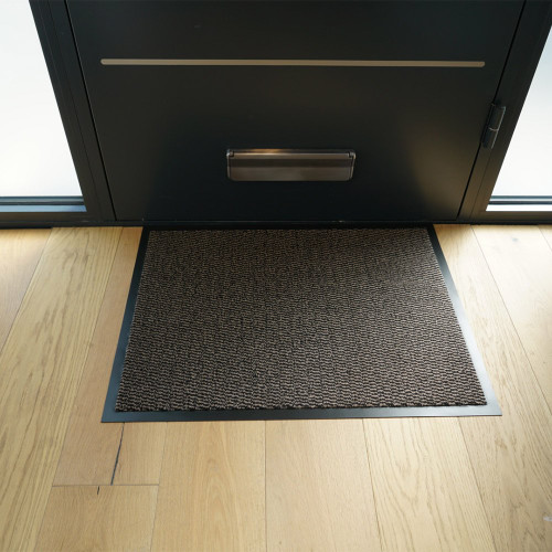 brown non-slip dirt trapper mat in front of a door outdoors