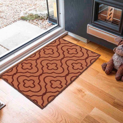 quatrefoil brown doormat in a door way on a wood floor