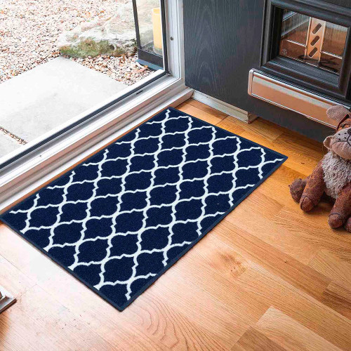 trellis navy doormat in front of open doorway on wood floor