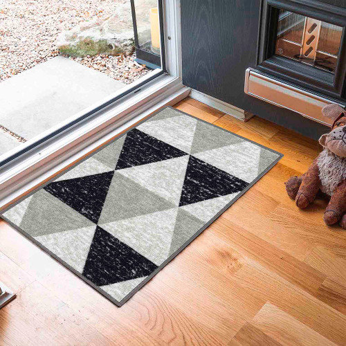 triangle grey doormat in front of open doorway on wood floor