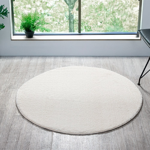 plain white rug circle in a living space with a window