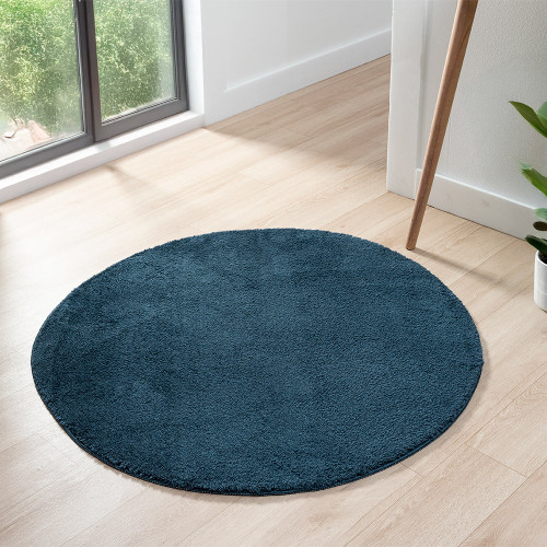 plain navy rug circle in a living space with a window