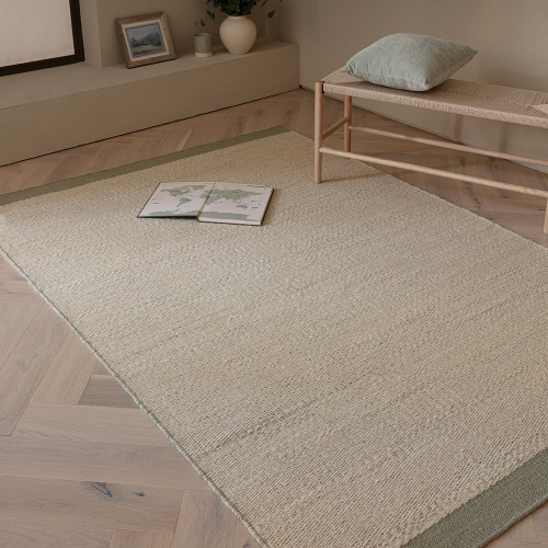sage flatweave wool rug in a living room with matching decor