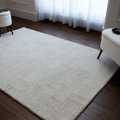 Contemporary living room interior styled with a large black and white geometric wool area rug beneath a modern sofa layout.