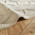 taupe wool rug closeup fold on wood floor