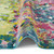multicolour abstract rug partially folded on a white floor