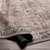 brown traditional rug partially folded on wood floor