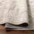 salmon traditional rug partially folded on wood floor