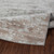 grey abstract rug folded on wood floor