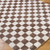 brown checker shaggy rug closeup corner on wood floor