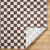 brown checker shaggy rug folded on wood floor