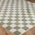 green checker shaggy rug closeup corner on wood floor