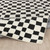 ivory black scandi rug folded on wood floor