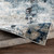 blue abstract rug folded on wood floor
