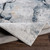 blue abstract rug folded on wood floor