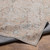 taupe traditional rug folded on wood floor