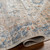 beige traditional rug folded on wood floor