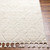 beige berber geometric rug closeup corner on wood floor