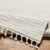 ivory berber geometric rug corner fold on wood floor
