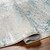 teal abstract rug corner fold on wood floor