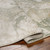 green abstract rug corner fold on wood floor